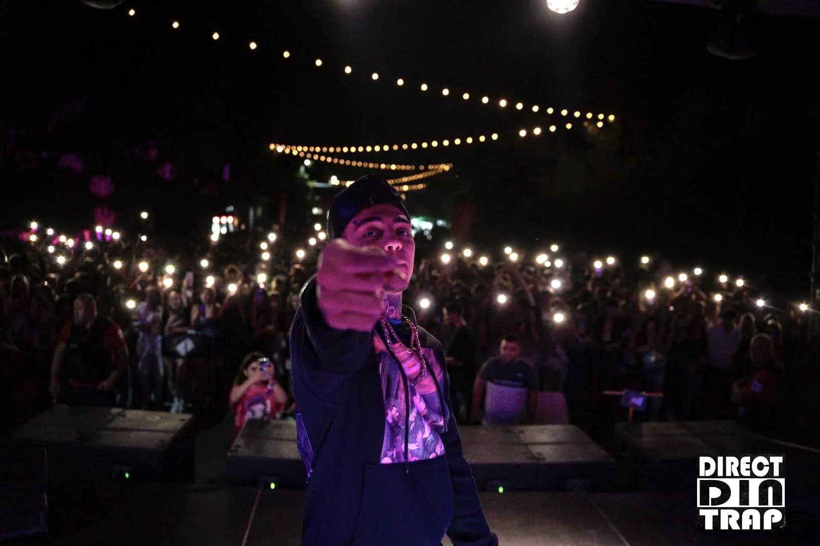 Artist pe scenă, publicul cu telefoanele ridicate